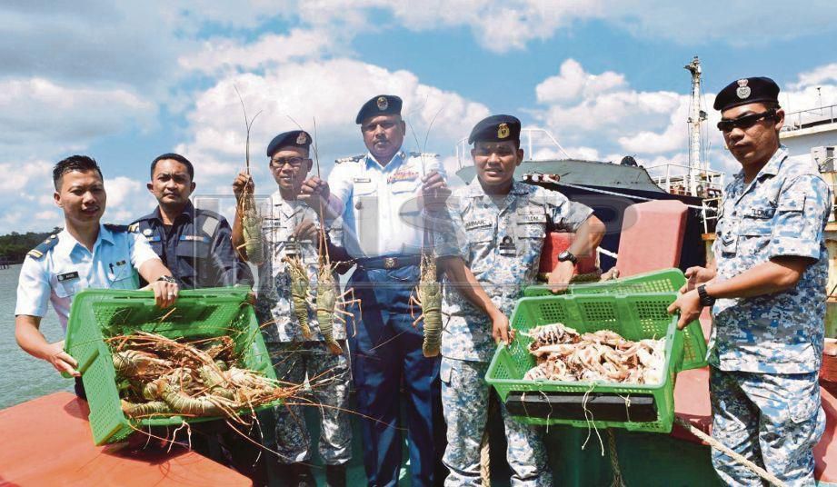 PANNIR Salvan (empat dari kiri) bersama anggota TLDM menunjukkan sebahagian hasil tangkapan selepas menahan dua bot nelayan Vietnam yang menceroboh perairan negara, Khamis lalu. FOTO Rosli Ilham.