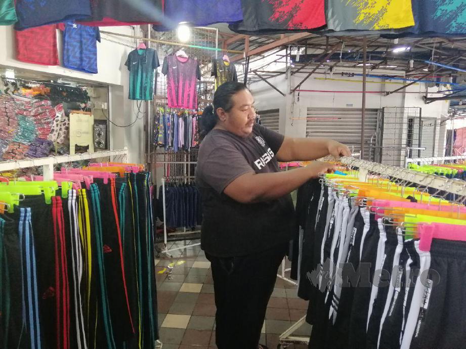 MOHD Zuwairie sedang mengemas pakaian yang dijualnya di Kompleks Hentian Majlis Bandaraya Kuala Terengganu (MBKT). FOTO ZATUL IFFAH ZOLKIPLY