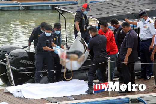 ANGGOTA APMM dan anggota polis mengangkat mayat kru bot tunda. FOTO Zulhairi Zuber