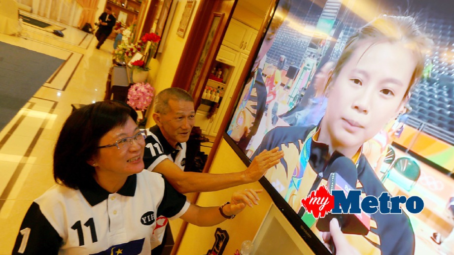 OOI Lin (kiri) dan Chak Whee(dua kiri) menonton siaran langsung penyampaian pingat kepada anaknya Liu Ying. FOTO Rasul Azli Samad