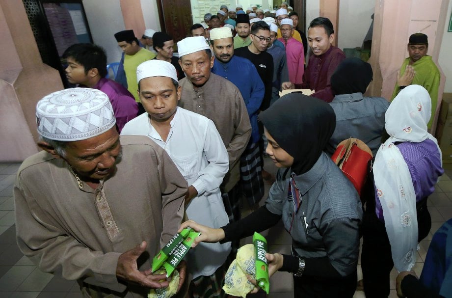 Kakitangan McDonald's menyampaikan makanan kepada sebahagian jemaah  selepas menunaikan solat Tarawih di Masjid Zaid Bin Haritsah pada program Moreh Bersama McDonald's.