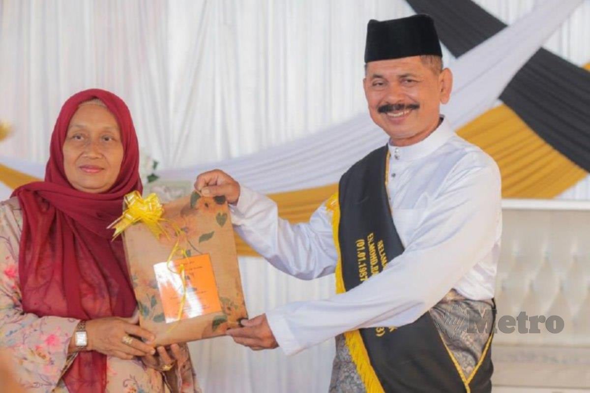 MOHD Radin menerima penghargaan daripada Pengetua, Maziah Mohamad di SMK Sri Gunung, Bachok. FOTO ihsan Mohd Radin Sidek