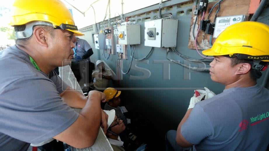 KAKITANGAN ST dan SESB memeriksa meter elektrik di sebuah kilang kerana disyaki melakukan pengusikan meter elektrik dalam serbuan hari ini. FOTO Edmund Samunting.