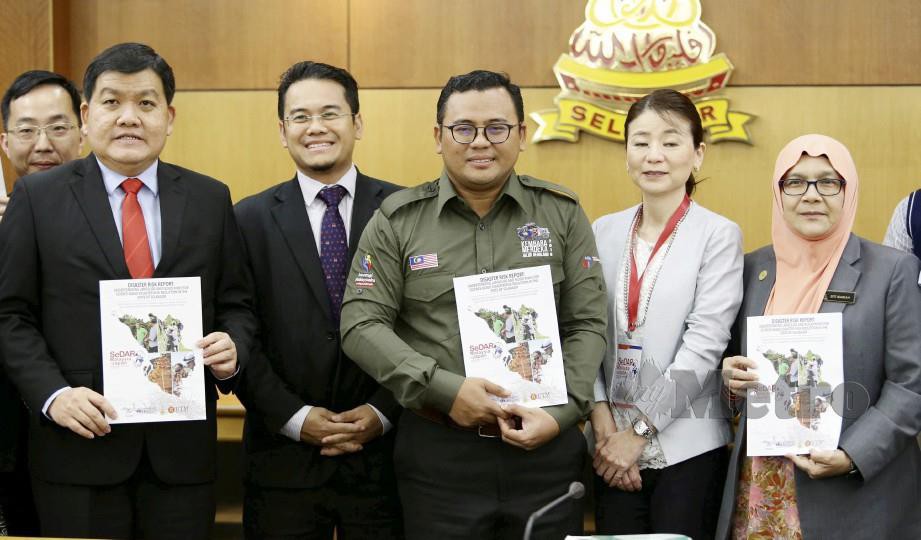 Amirudin (tengah) bersama exco negeri menunjukkan buku laporan risiko bencana selepas mempengerusikan mesyuarat bencana alam di Shah Alam hari ini. Foto Roslin Mat Tahir 