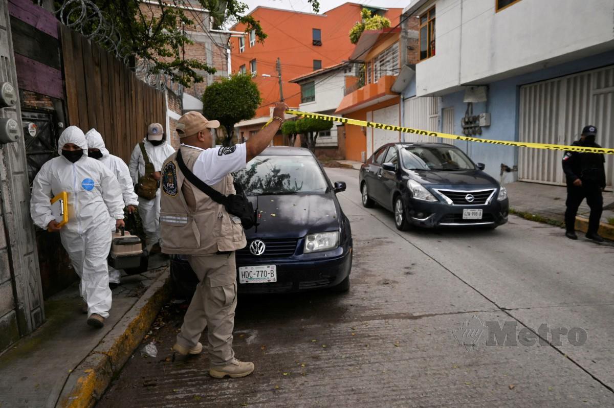 PASUKAN forensik menjalankan siasatan di lokasi kejadian pembunuhan Roman. FOTO Reuters