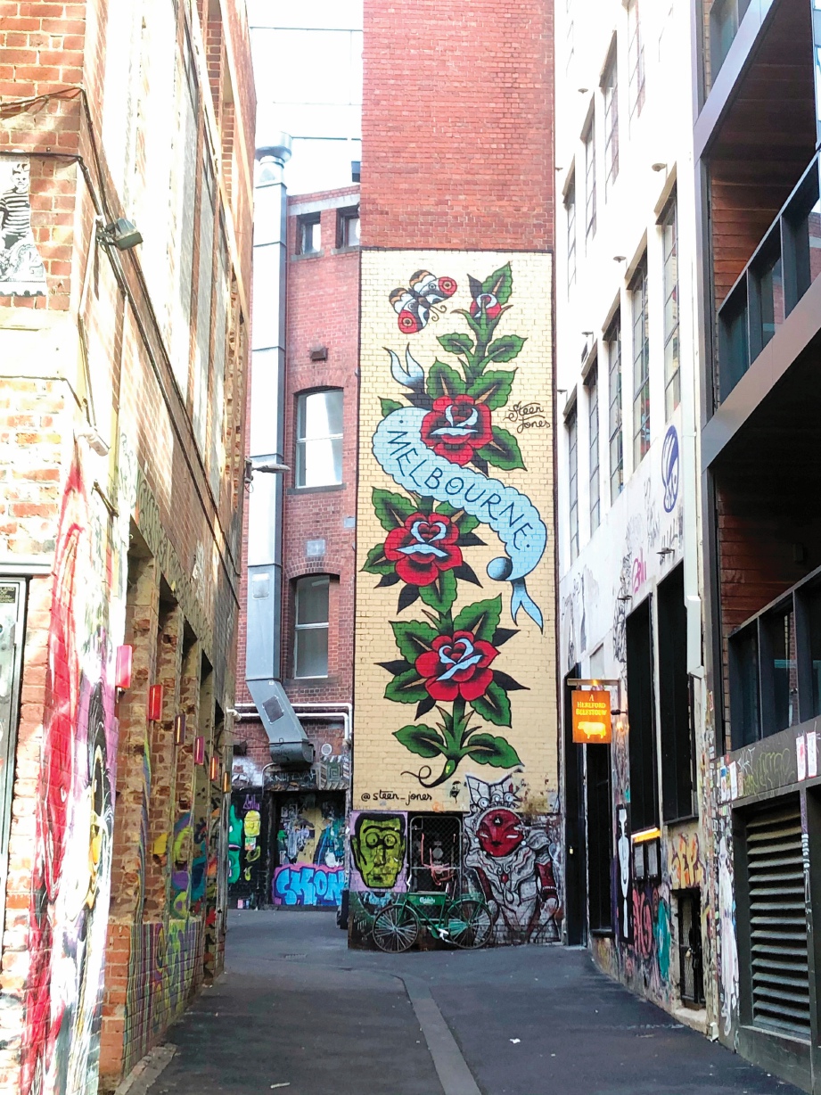 IMEJ bunga dan tulisan Melbourne di Duckboard Place, bangunan hujung laluan AC/DC Lane menghala ke Flinders Street.