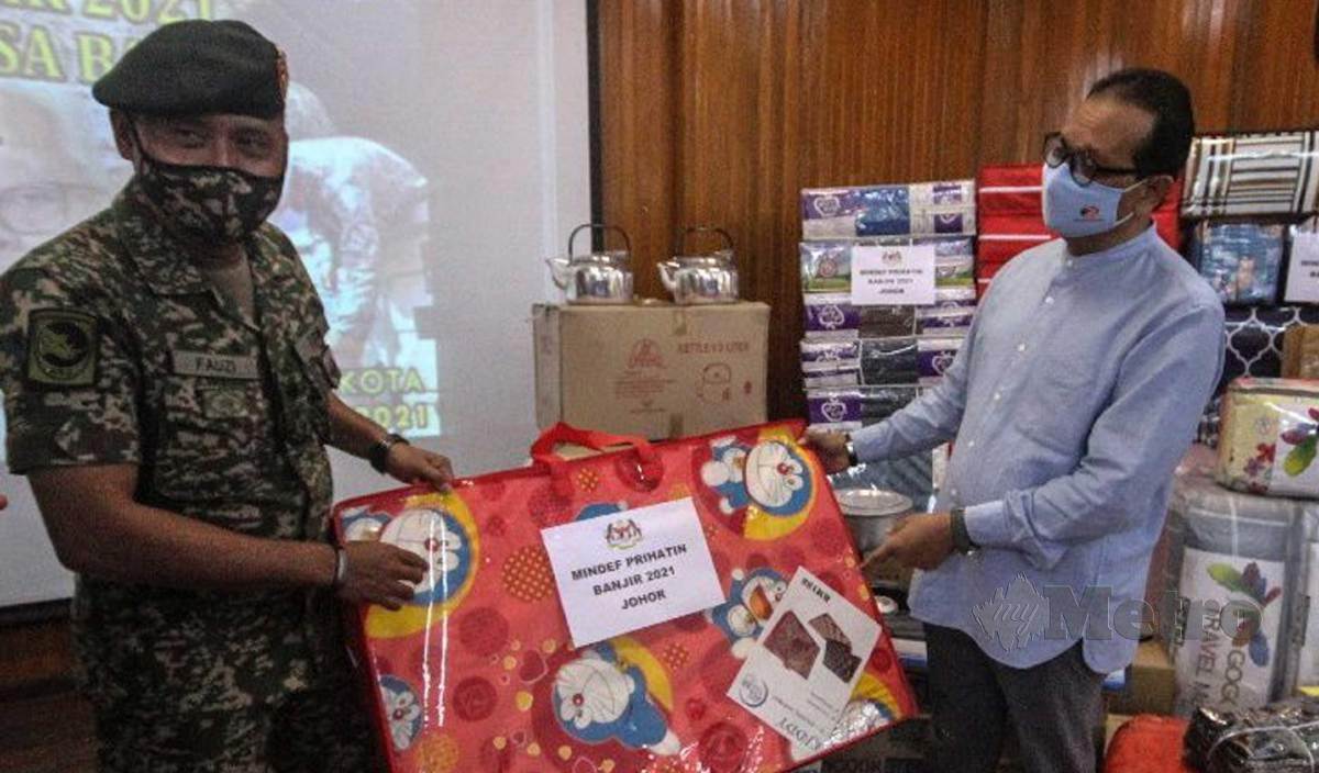 SAMSOLBARI (kanan) menerima sumbangan melalui program "Bantuan MINDEF Prihatin" yang disampaikan oleh Panglima 7 Briged, Brigedier Jeneral Mohamed Fauzi Kamis di Dewan Mahkota di Kem Mahkota, Kluang. FOTO Adnan Ibrahim