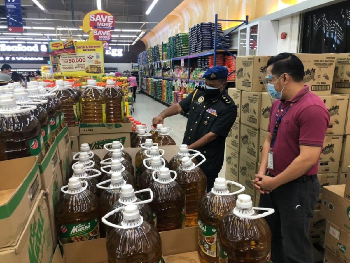 Mogan Arumugam memeriksa harga minyak masak di Kuching. FOTO IHSAN KPDNHEP