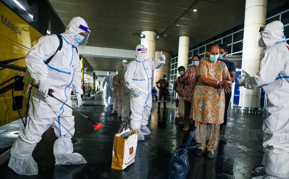 ANGGOTA Bomba dan Penyelamat melakukan kerja-kerja sanitasi ke atas bagasi penumpang yang turun dari pesawat. Seramai 107 orang penumpang yang terdiri daripada 62 orang jemaah tabligh, 34 orang gabungan kakitangan kedutaan Malaysia dan rakyat Malaysia yang terkandas sejak lapangan terbang India ditutup manakala baki 11 orang merupakan krew Malindo Air selamat tiba di lapangan Terbang Antarabangsa Kuala Lumpur hari ini. FOTO LUQMAN HAKIM ZUBIR