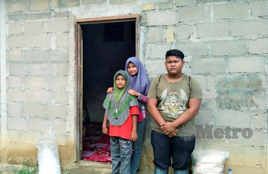 MOHAMAD Syahadam bersama dua adiknya di rumah serba kekurangan. FOTO Ramli Ibrahim