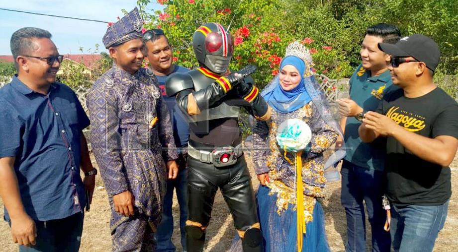 Mohd Farid berpakai adiwira Kamen Rider Black (tengah) bergambar bersama pengantin dan tetamu. FOTO Nor Amalina Alias