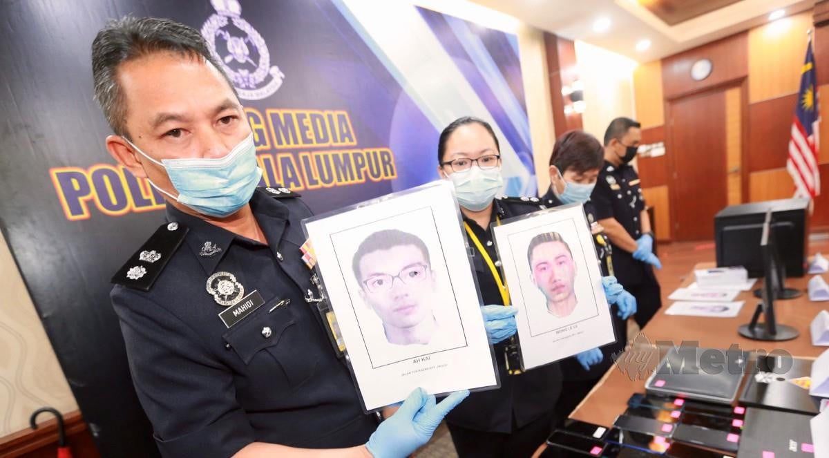 Mahidisham (kiri) menunjukkan gambar suspek dan barang rampasan dalam kes penipuan tawaran kerja e-dagang pada sidang media di IPK Kuala Lumpur. FOTO Fathil Asri