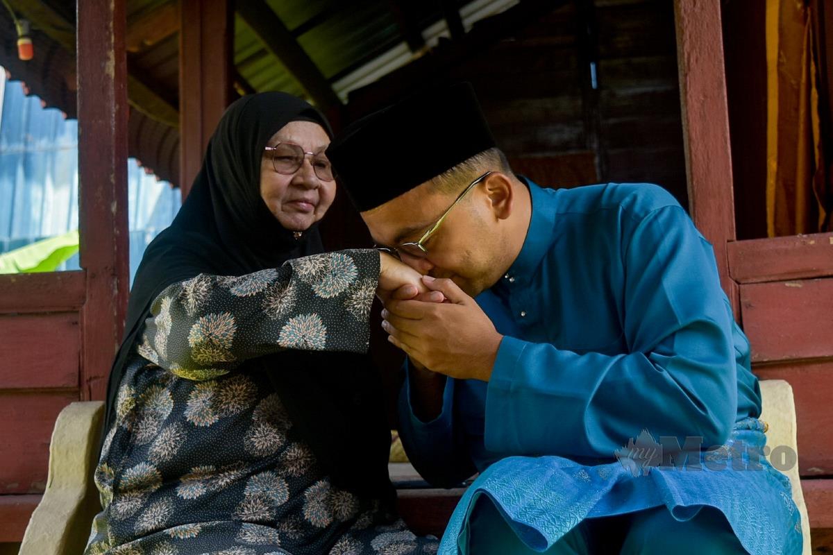 Calon Perikatan Nasional N.23 Telok Mas, Datuk Mohd Rafiq Naizamohideen memohon doa dan restu daripada ibunya, Hanifah Othman di Kampung Ujong Pasir. FOTO Asyraf