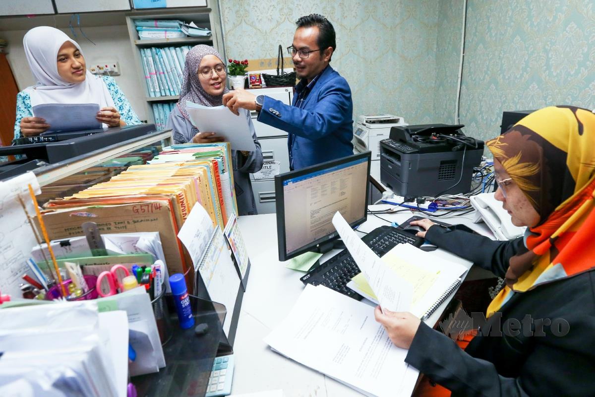 RAKAN kongsi Fariz Halim & Co, Mohd Redzuan (tengah) bersama kakitangannya ketika ditemui di pejabatnya.