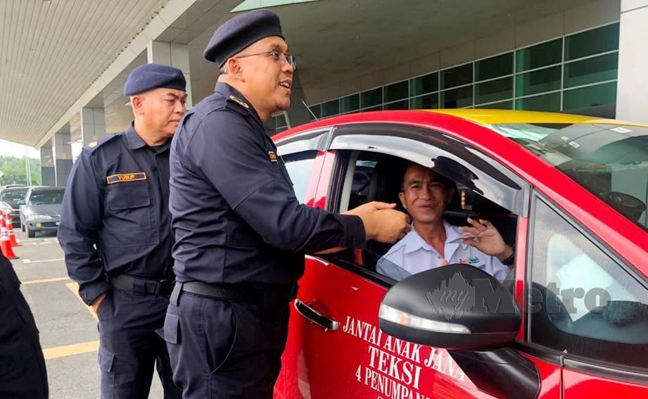 PENGARAH Jabatan Pengangkutan Jalan (JPJ) Sarawak, Mohd Syafiq Anas Abdullah membuat pemeriksaan kepada seorang pemandu teksi yang juga pemandu e-hailing dalam operasi, di Lapangan Terbang Sibu. FOTO Harun Yahya