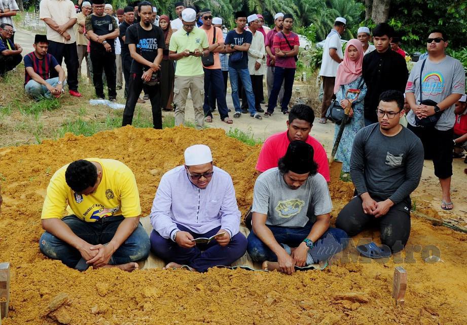 Muhammad Fadhil (duduk, kanan) bersama abangnya, Muhammad Firdaus (duduk, kiri) dan Muhammad Faiz (duduk dua, kanan) ketika bacaan talkin selepas jenazah bapa mereka, Mohd Zonis Mokhtar selamat dikebumikan.FOTO Bernama