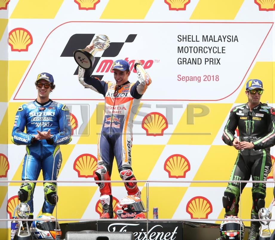 MARQUEZ (tengah) meraikan kejayaannya manakala Rins (kiri) menduduki tempat kedua dan Zarco di tempat ketiga pada perlumbaan MotoGP 2018 GP Shell Malaysia di Sirkit Antarabangsa Sepang, hari ini. FOTO Nur Adibah Ahmad Izam.