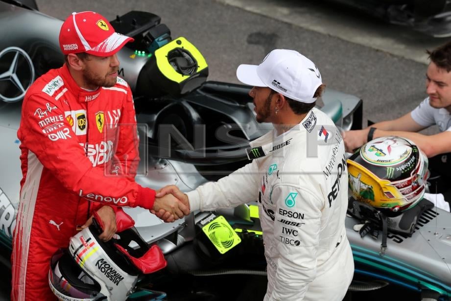 HAMILTON (kanan) bersalaman dengan Vettel selepas mereka menguasai petak utama dan kedua menjelang perlumbaan GP Brazil, awal pagi esok. FOTO Reuters 