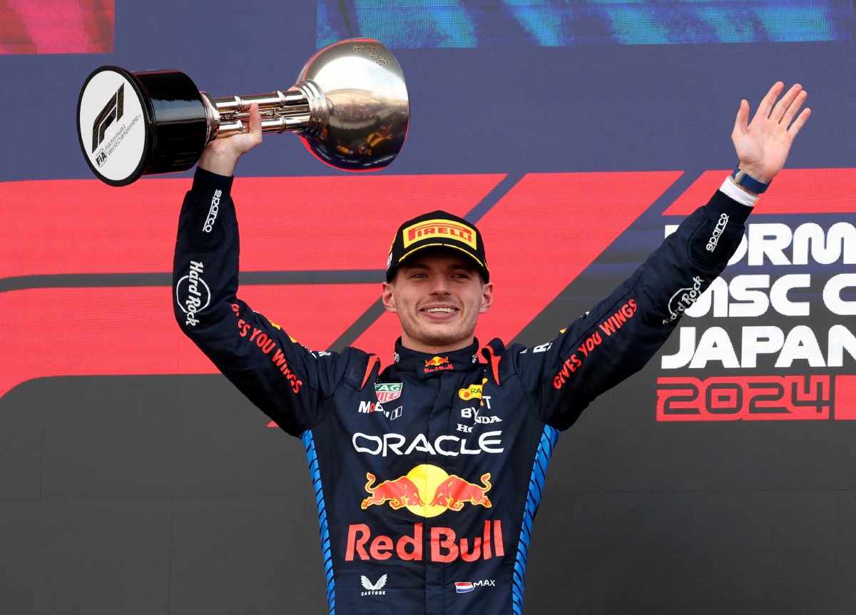 VERSTAPPEN meraikan kejayaan bersama trofi kejuaraan di GP Jepun. -FOTO Reuters 