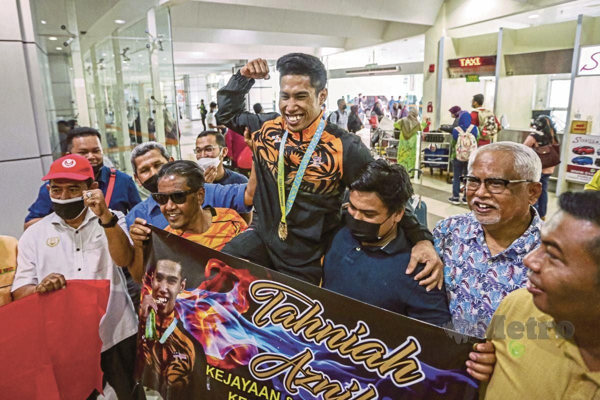 ATLET angkat berat negara, Muhamad Aznil Bidin, 28, yang memenangi pingat emas dan mencatat rekod baharu Sukan Komanwel Birmingham 2022 disambut orang ramai ketika tiba di Lapangan Terbang Sultan Abdul Halim, Alor Setar, semalam. FOTO LUQMAN HAKIM ZUBIR