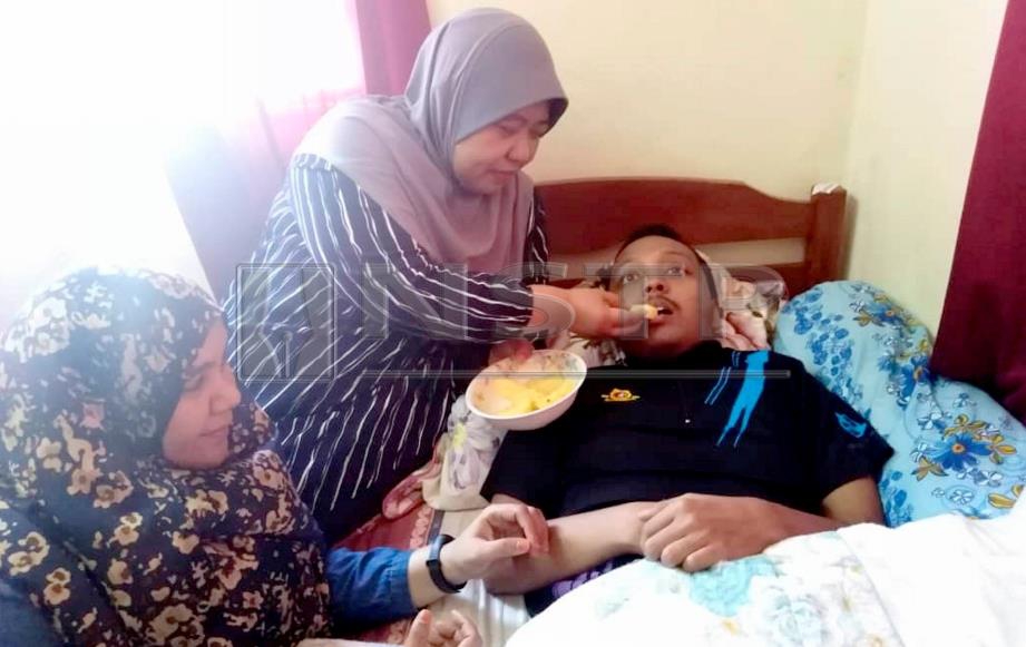 HAMIZA menyuapkan buah ke mulut Muhamad Iqmal yang menghidap kanser limfoma tahap empat sambil diperhatikan Norashikin di rumah mereka di Kampung Titi Serong, Yan, hari ini. FOTO Zuliaty Zulkiffli.