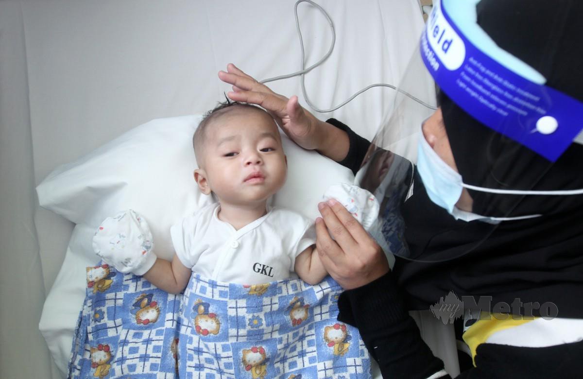 ROZALIA bersama anaknya, Muhammad Jayden Rifiansyah yang memerlukan sumbangan RM70,000 untuk menjalani pembedahan jantung berlubang di Hospital Gleneagles Kuala Lumpur. FOTO Aziah Azmee