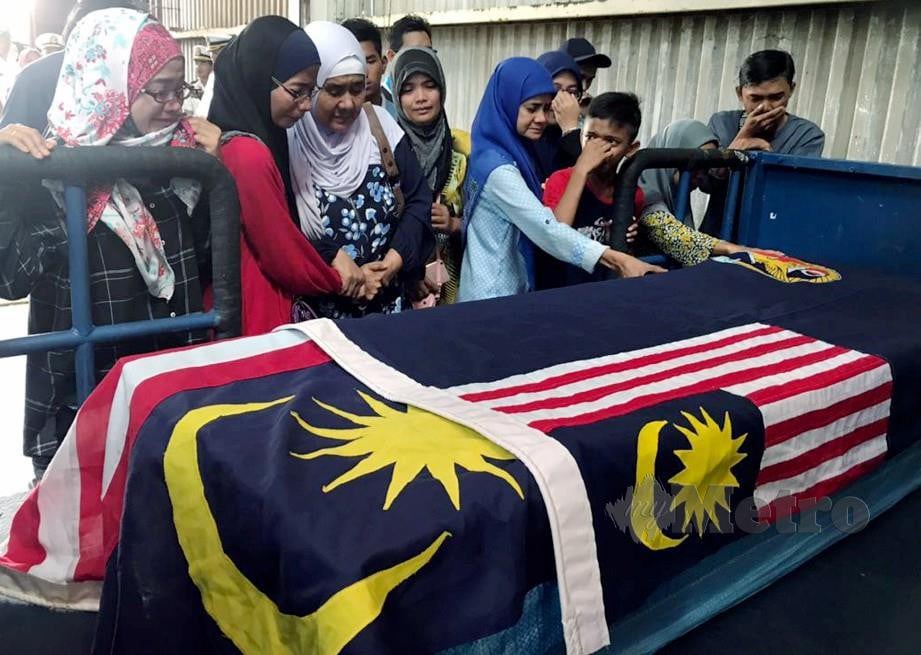 AHLI keluarga memberi penghormatan terakhir kepada jenazah Muhammad Nazrin Tarmidi sebelum diterbangkan pagi ini dari Lapangan Terbang Sandakan ke Negeri Sembilan. FOTO Ihsan APMM.