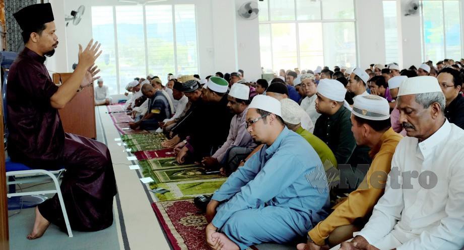 GURU Pendidikan Khas, Muhammad Nidzam Shafiff Fudin, 35 membantu golongan jemaah OKU menterjemah khutbah Jumaat dengan  bahasa isyarat di Masjid Tepian Putra. FOTO Farizul Hafiz Awang 