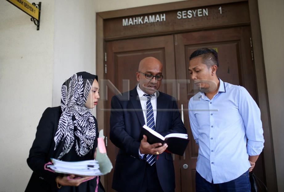 Muhammad Nizam (kanan) bersama  peguam, M Haresh berbincang di luar mahkamah selepas diarah membela diri. FOTO Hazreen Mohamad