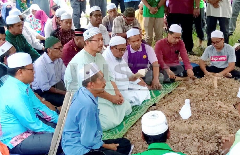 KETUA Dewan Ulama PAS Melaka, Zulkifli Ismail (empat dari kanan) membaca talkin selepas arwah Mustaffa selamat dikebumikan di Tanah Perkuburan Kampung Padang Lalang, Jempol. FOTO Abnor Hamizam.