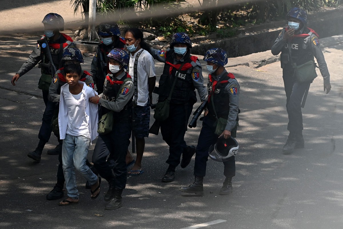 POLIS menanhan penunjuk perasaan di Yangon. FOTO AFP