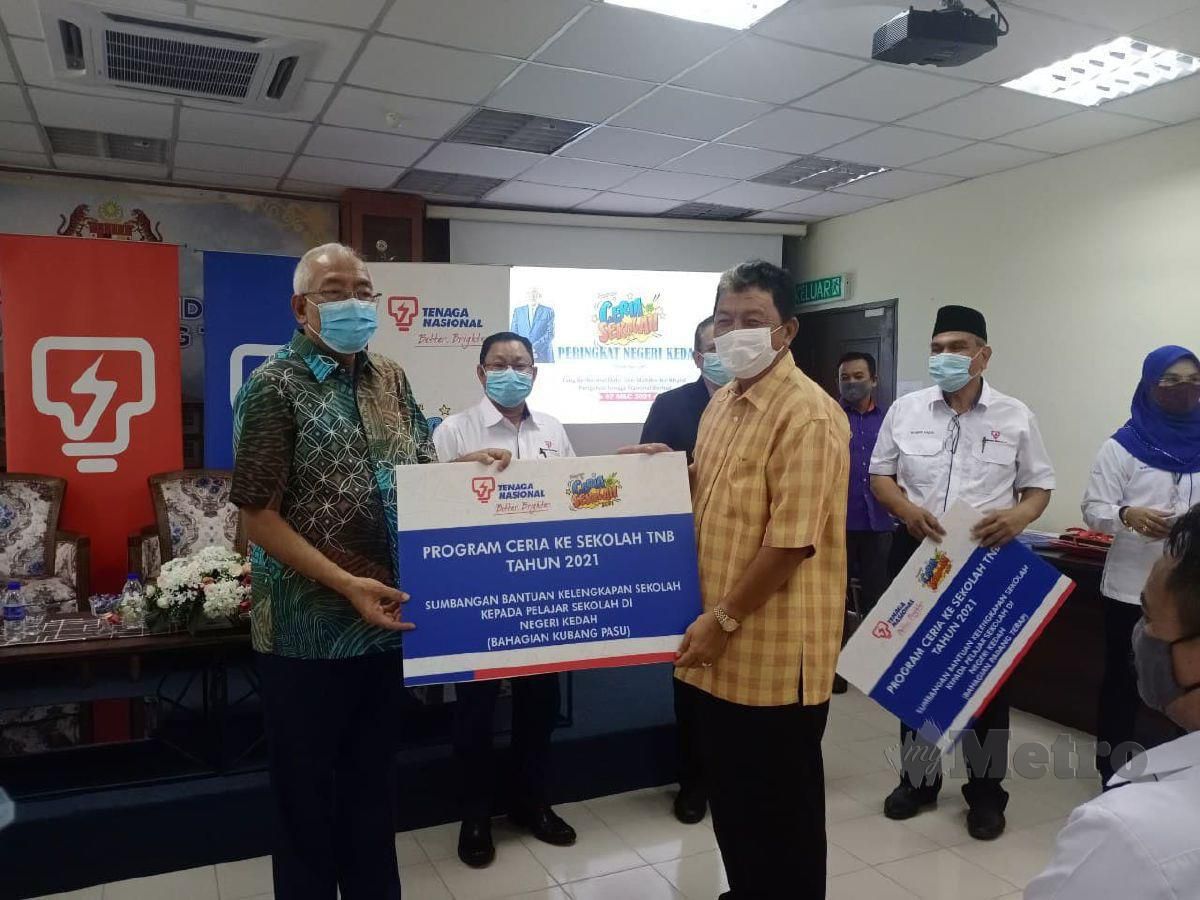 MAHDZIR Khalid menyerahkan replika sumbangan kepada wakil setiap bahagian UMNO di Kedah pada pada Program Ceria ke Sekolah CSR TNB di Pejabat Pendidikan Daerah Padang Terap, di sini, hari ini. FOTO Noorazura Abdul Rahman
