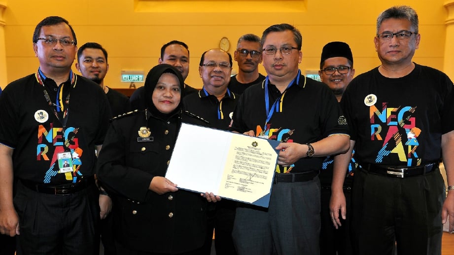 Ketua Pengarah Jabatan Insolvensi Malaysia, Datuk Abdul Rahman Putra Taha (duadari kanan) menyerahkan Ikrar Bebas Rasuah kepada Timbalan Pesuruhjaya Suruhanjaya Pencegahan Rasuah (SPRM), Datuk Junipah Wandi (dua, kiri) pada majlis Penutupan Sambutan Bulan Kemerdekaan 2017 di Jabatan Insolvensi. FOTO BERNAMA 
