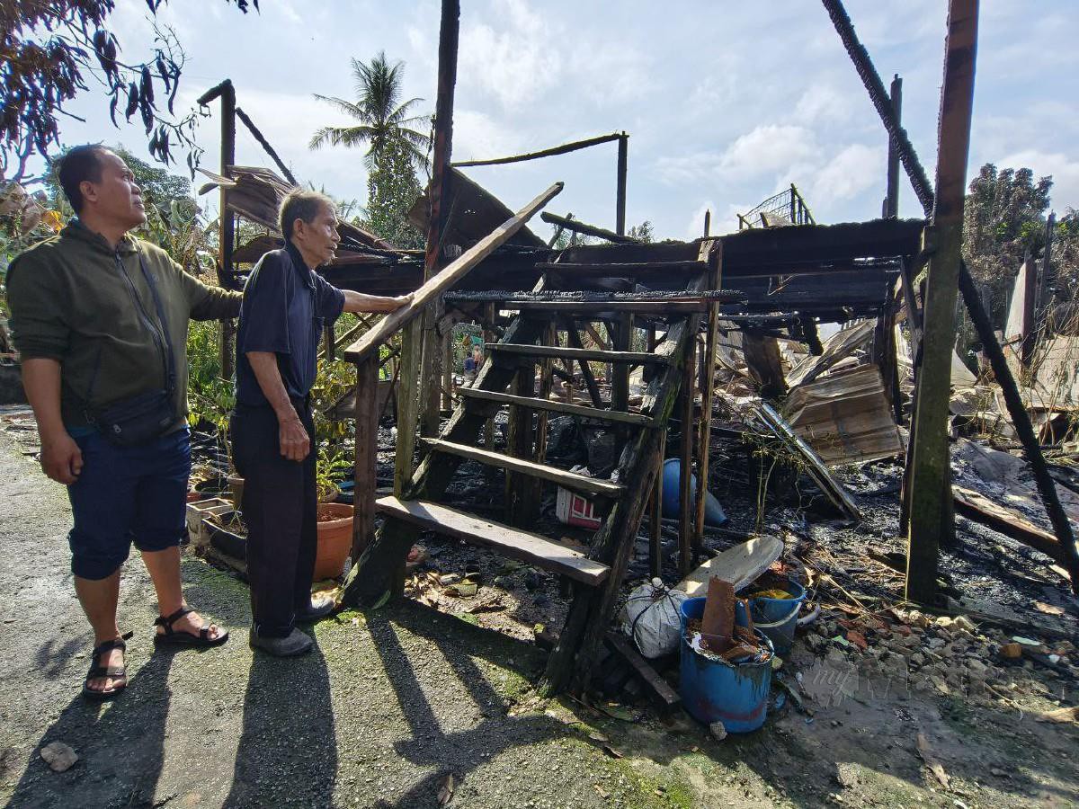 SUHAILI (kanan) sayu melihat rumahnya yang musnah dalam kebakaran di Kampung Pulo Ulu, Petra Jaya, awal pagi tadi. FOTO Mohd Roji Kawi