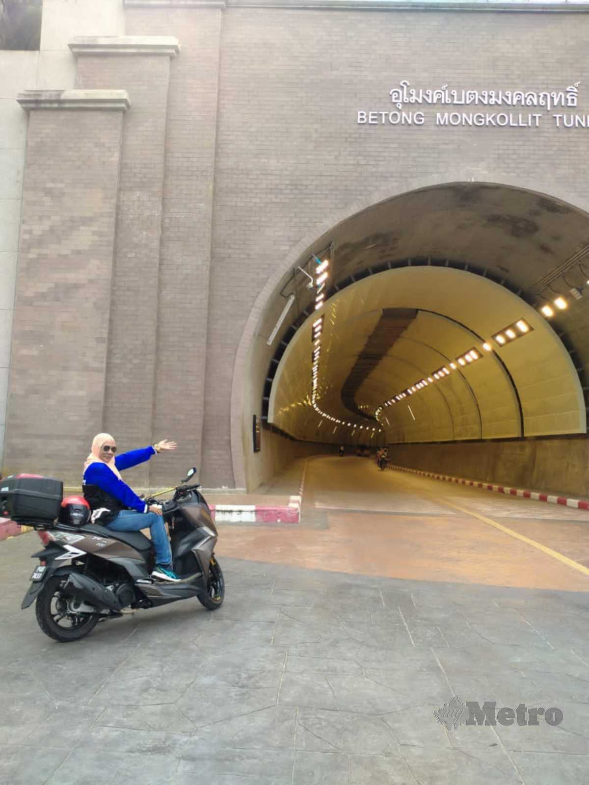 BERGAMBAR di hadapan terowong Betong, Thailand bersama motosikal skuter SYM 200.