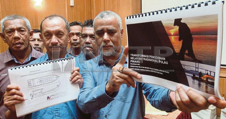 NAZRI (kanan) bersama Mahadi (dua dari kiri) menunjukkan kertas kerja bertajuk 'Transformasi Pemodenan Nelayan Tradisional Pulau Pinang' pada sidang media di Batu Maung, Georgetown, hari ini. FOTO Danial Saad.