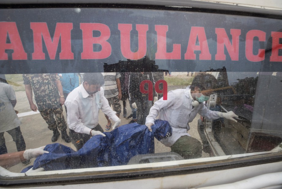 KAKITANGAN dan anggota polis mengalihkan mayat pendaki di helipad Hospital Pengajaran di Kathmandu. FOTO EPA