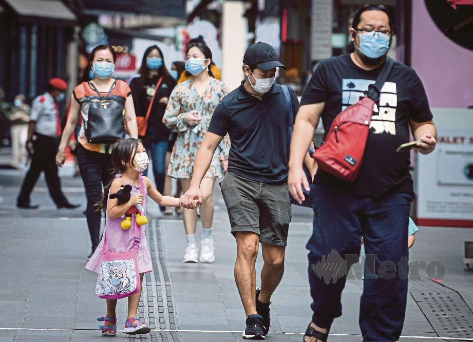 Orang ramai dilihat mengamalkan jarak sosial dan memakai pelitup muka semasa melintasi laluan pejalan kaki ketika tinjauan norma baharu warga kota di sekitar Jalan Bukit Bintang.