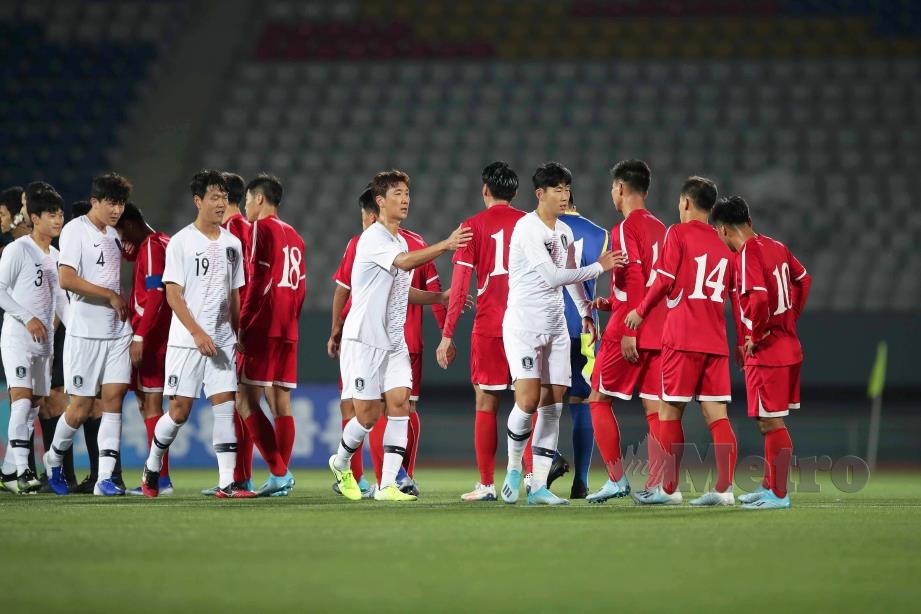 PEMAIN bola sepak Korea Selatan dan Korea Utara bersalaman.