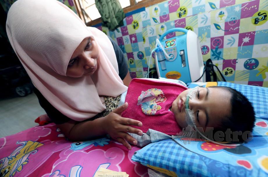 NURUL Ashafiqah melihat anaknya, Nur Iman Fitriah, yang mengidap penyakit sawan saraf ketika ditemui di Pangsapuri Sri Perdana, Paroi, Negeri Sembilan. FOTO Iqmal Haqim Rosman