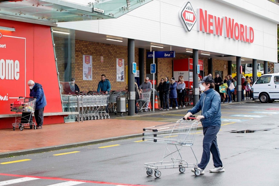 ORANG ramai beratur di luar sebuah pasar raya di Devonport, Auckland, bagi memberi barangan keperluan sebelum perintah ‘lockdown’. FOTO AFP 