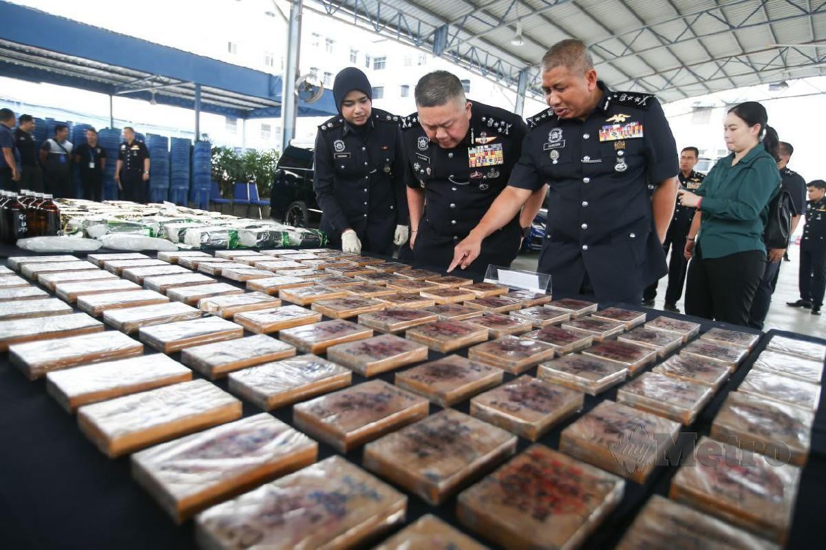 KOK Chin (tengah) melihat rampasan dadah disyaki heroin base pada sidang media di Ibu Pejabat Kontinjen Pulau Pinang hari ini. FOTO Mikail Ong