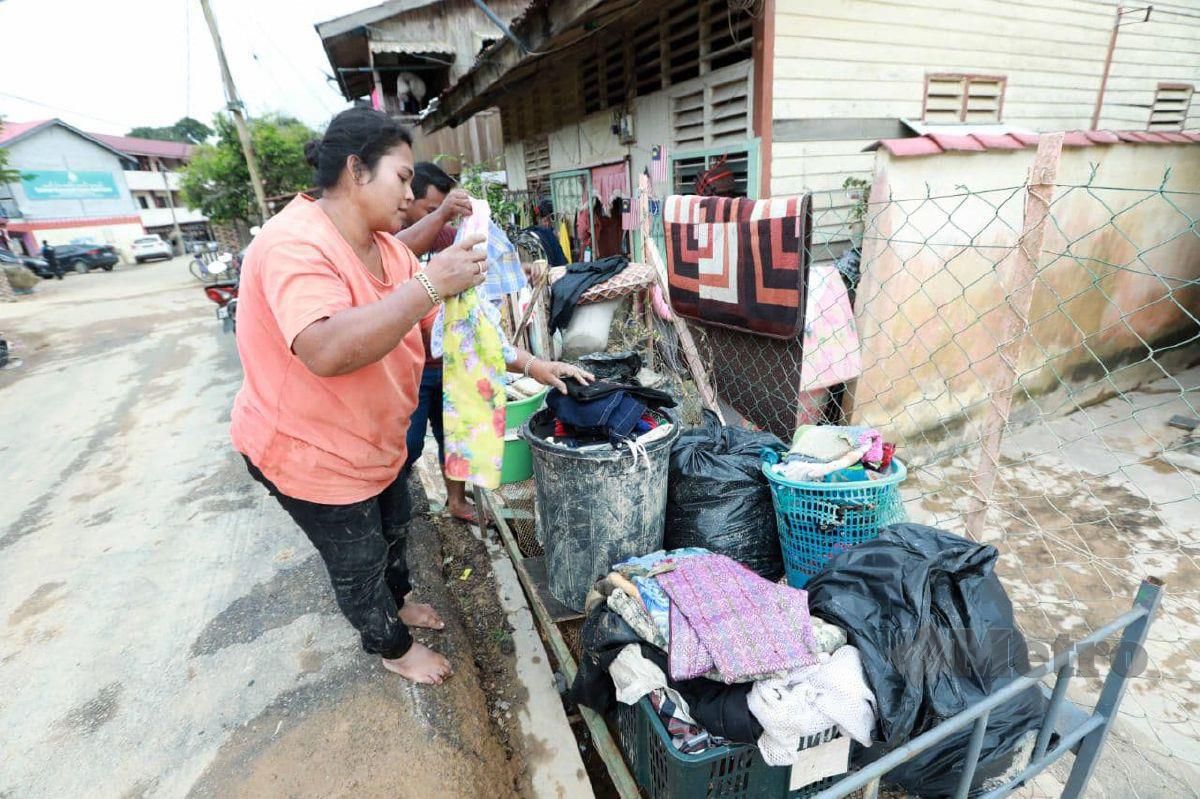 NOLIA memilih pakaian selepas rumahnya di Kampung Baru Kuala Krau ditenggelami banjir. FOTO MOHD RAFI MAMAT