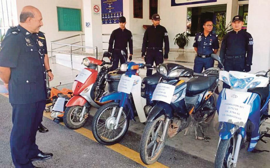 MOHD Ismail (kiri) bersama anggota Task Force Lejang IPD Kubang Pasu melihat motosikal curi ditemui semula hasil penahanan dua suspek. FOTO Zuliaty Zulkiffli.