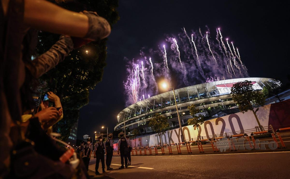ORANG ramai menyaksikan persembahan bunga api pada upacara pembukaan Sukan Olimpik Tokyo 2020 di Stadium Olimpik, malam ini. FOTO AFP