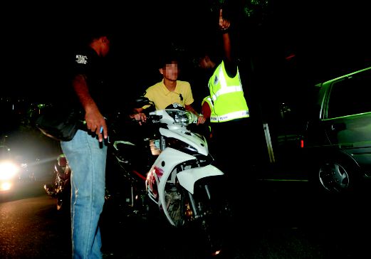 ANGGOTA polis menahan penunggang motosikal dalam operasi di  Dataran Kemerdekaan Shah Alam. 