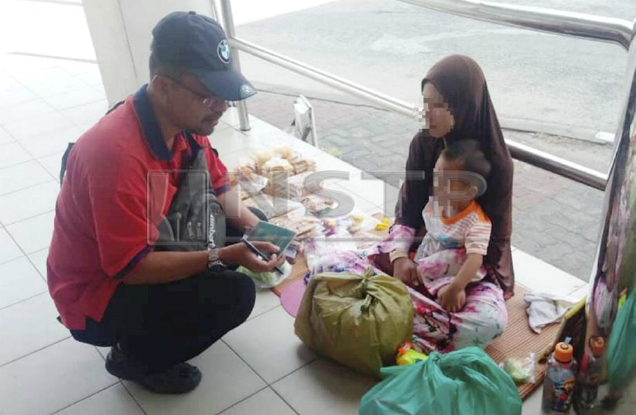 WANITA warga Thailand menjual kerepek sambil meriba anak berusia dua tahun ketika disoal siasat anggota JIM Kelantan dalam Ops Bersepadu (Kutip) di Kota Bharu. FOTO Ihsan Jabatan Imigresen Kelantan