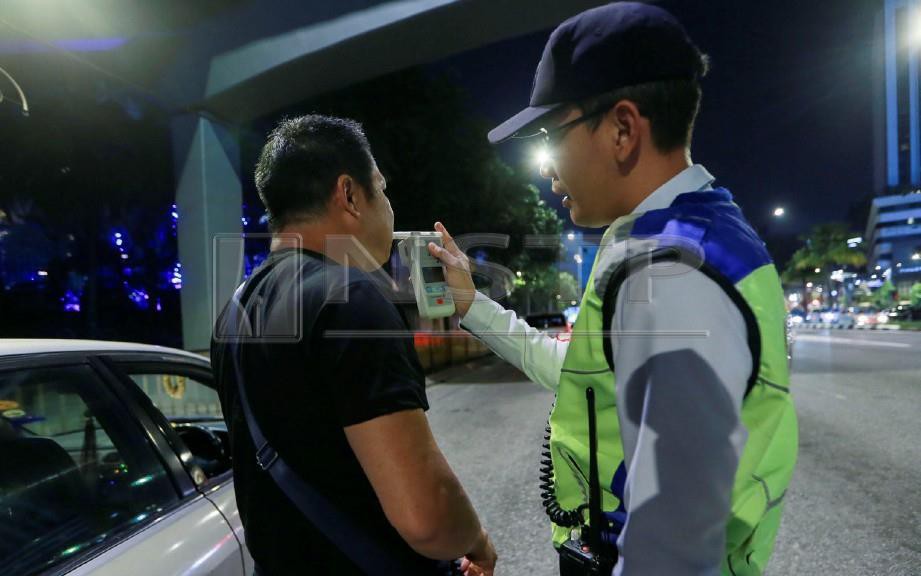 ANGGOTA  Jabatan Penguatkuasaan dan Siasatan Trafik (JSPT) Kuala Lumpur memeriksa kandungan alkohol menggunakan alat pengesan kandungan alkohol ketika Operasi Mabuk yang dijalankan di Jalan Kampung Pandan. FOTO Hafiz Sohaimi