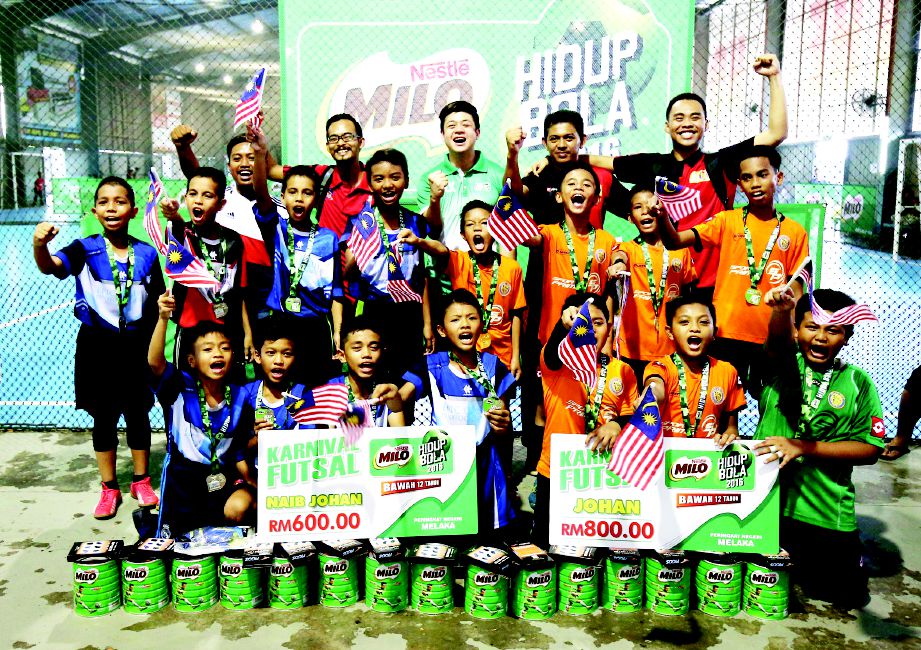 KERWIN (belakang tengah) meraikan kejayaan dua pasukan terbaik kategori B-12 di Zaba Samura SP Futsal Centre, Melaka.