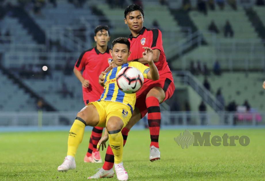 Wan  Zaharulnizam Wan Zakaria (depan) dikawal pemain PIB FC dalam saingan Piala FA di Stadium Darul Makmur. FOTO Zulkepli Osman.